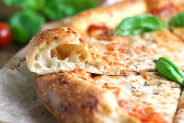 The pizza is on the board. One piece is cut and you can see what kind of dough