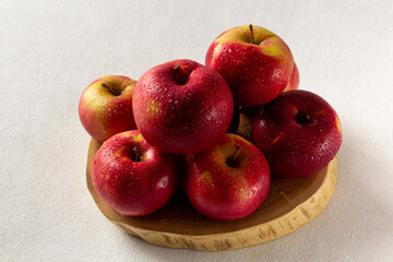 Fresh ripe red apples on a gray background, side view, vegetarian delicious product in the morning sun