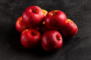 Fresh ripe red apples on a dark background, side view, vegetarian delicious product in a dark key