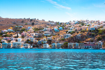 View on Greek sea Symi island harbor port, houses on island hills.