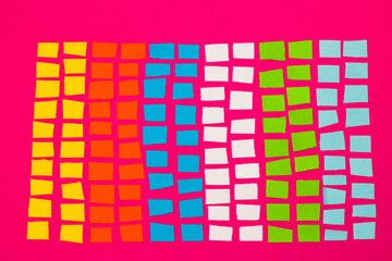 colorful paper blocks, a sheet of chopped paper on a pink background