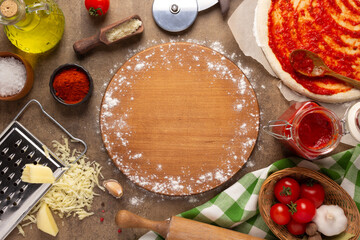 Pizza cutting board and ingredients on table. Bread recipe cooking at tabletop background