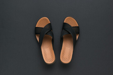 Elegant women's sandals on a black background. Minimal concept of summer women's shoes.