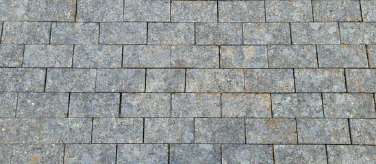 Texture of concrete pavement or sidewalk with paving slabs, top view. Blocks of the sidewalk pattern, details of the stone-tiled path.