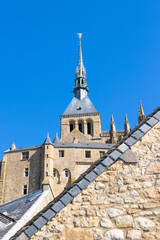 Fototapeta premium Vue depuis les contrebas sur l'Abbaye du Mon Saint-Michel et son clocher surmonté de l'Archange Saint-Michel