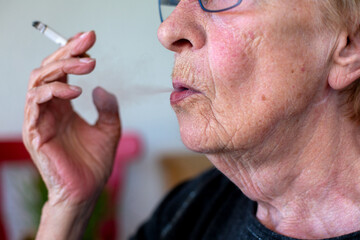 close-up of an old woman smoking a cigarette