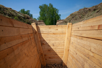 dug in the ground and reinforced with improved boards trench