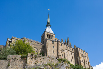 Vue depuis les contrebas sur l'Abbaye du Mon Saint-Michel et son clocher surmonté de l'Archange Saint-Michel