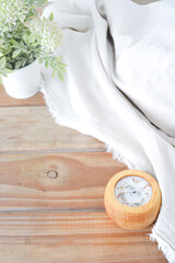 Linen fabrics with flowers and candle on wooden background