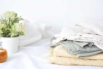 Linen fabrics with flowers and candle on white background