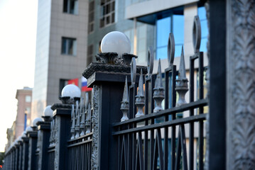 Iron fence with pins and lanterns in the city
