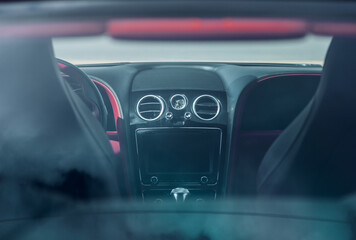 Fototapeta premium Digital screen on a cars dashboard viewed through the rear window