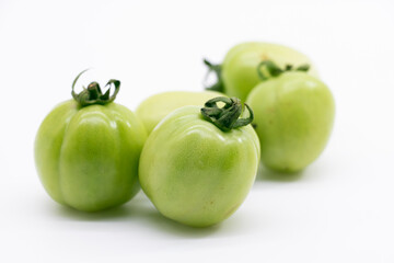 Fresh green unripe tomatoes isolated on white background.