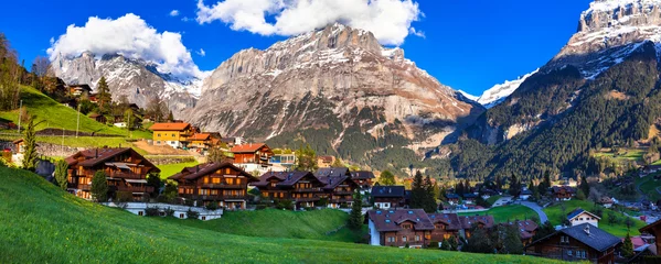 Foto auf Leinwand Switzerland nature and travel. Alpine scenery. Scenic traditional mountain village Grindelwald surrounded by snow peaks of Alps. Popular tourist destination and ski resort © Freesurf
