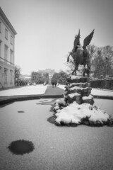 Naklejka premium Pegasus Statue im Mirabellgarten Schloß Mirabell Salzburg im Winter mit Schnee und Eis und Pärchen spazieren in Schwarz/weiß austria, Pegasus in Mirabell Garden in winter with snow in black and white 