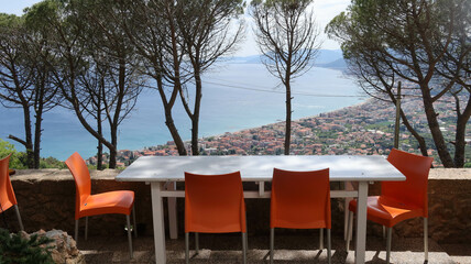 tables of a restaurant in a garden with a splendid sea view, in the hinterland of western Liguria in Borgio Verezzi