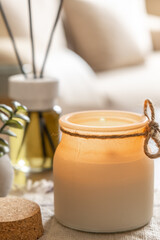 Burning aroma candle and air freshener on table, decor elements, spa and relax concept, free space for text