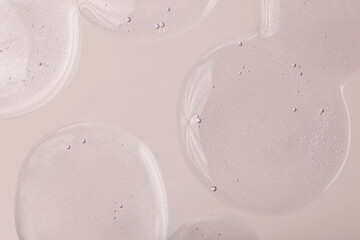 Fototapeta na wymiar Top view of liquid cosmetics gel with bubbly structure on pastel beige background.Good as cosmetic mockup.