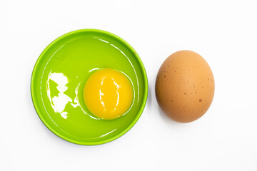 whole egg and broken in a plate isolated on white background.view from above