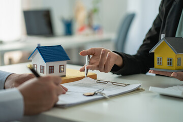 Home agents talk to new home buyers and offer good interest rates and calculate clients on mortgage financing to help make real estate concept decisions.
