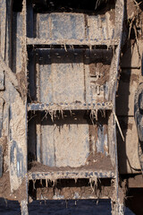 the metal ladder on the tractor is covered in dirt after agricultural work