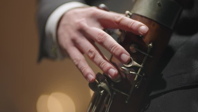 musician is playing bassoon closeup view of hands, pressing holes by fingers, classic music instrument
