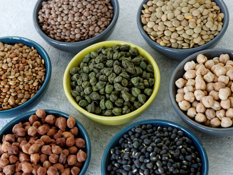 Assortment of dry chickpea and lentils in bowls.