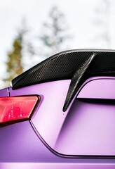 Purple car with a rear spoiler being viewed from below