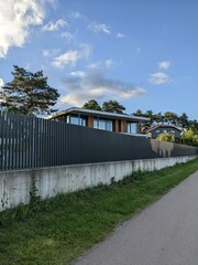modern fenced cottage on the blue sky background 