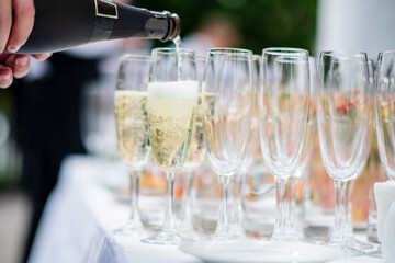 Waiter pouring champagne into glass