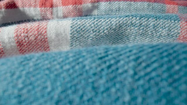 Warm woolen plaid shirt background in macro. The structure of the garment, textile material, soft fabric made of wool or cotton. White, blue, red checkered cloth. Clothes texture close up.
