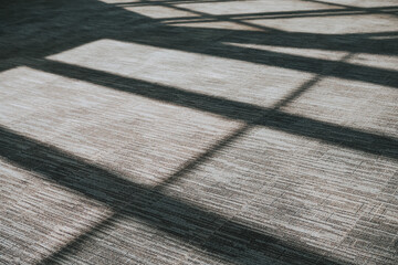 Shadows from the sun on the gray floor. Contrasting background with shadows