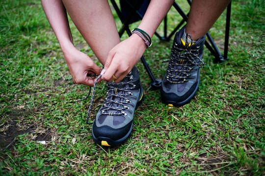 Close Up Of Woman Hand Tying Hiking Shoes. Unrecognizable Women Lacing Shoe Outdoors