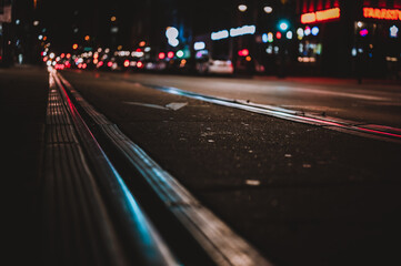 Street level selective focus on trolley rail lines at night in San Diego.