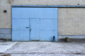 blue metal sliding door in a white brick wall
