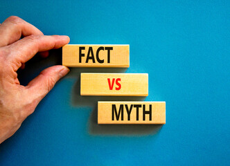 Fact vs myth symbol. Concept words Fact vs myth on wooden blocks on a beautiful blue table blue background. Businessman hand. Business, finacial and fact vs myth concept. Copy space.