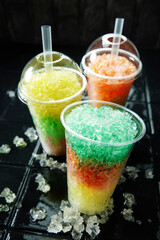 Three colorful slush drinks on black background