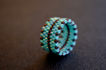 A  turquoise beaded ring on black surface,isolated ring on black background.