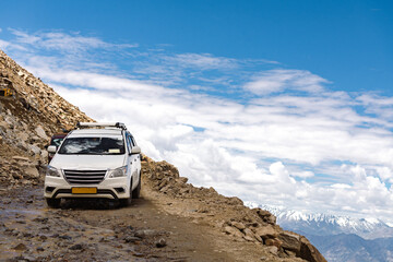 A tourist car traverses a small mountain pass