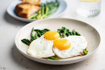 Fried eggs with green asparagus. Fast lunch ideas, healthy breakfast, summer food.