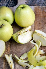 sliced and peeled green apple on a wooden board