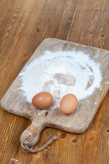 chicken eggs and wheat flour on a cutting board during cooking