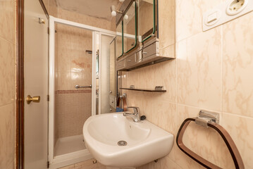 Vintage bathroom with kitsch tiles, white toilets and white aluminum screen, rectangular mirror cabinet and glass and chrome metal accessories