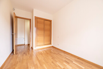 Empty room with French oak parquet floors with matching built-in wardrobe with sliding doors