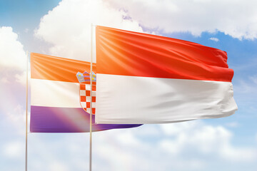 Sunny blue sky and flags of indonesia and croatia