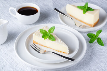 Cheesecake and cup of black coffee on a white table