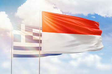 Sunny blue sky and flags of indonesia and greece