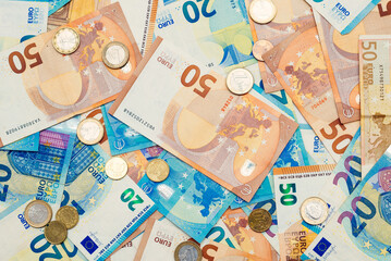 50 and 20 euro banknotes and euro coins arranged randomly