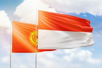 Sunny blue sky and flags of indonesia and kyrgyzstan