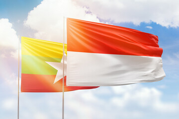 Sunny blue sky and flags of indonesia and myanmar